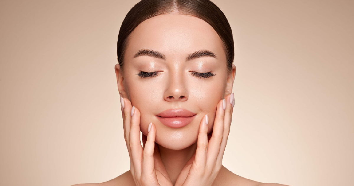 Woman with glowing, smooth skin touching her face after Medical Facials in Cheyenne, WY, showing rejuvenation and youthful results.
